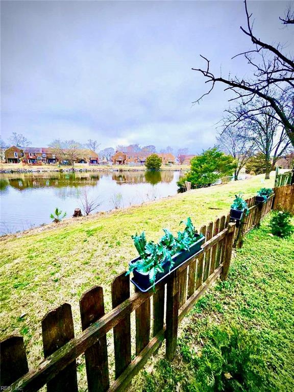 view of yard featuring fence and a water view