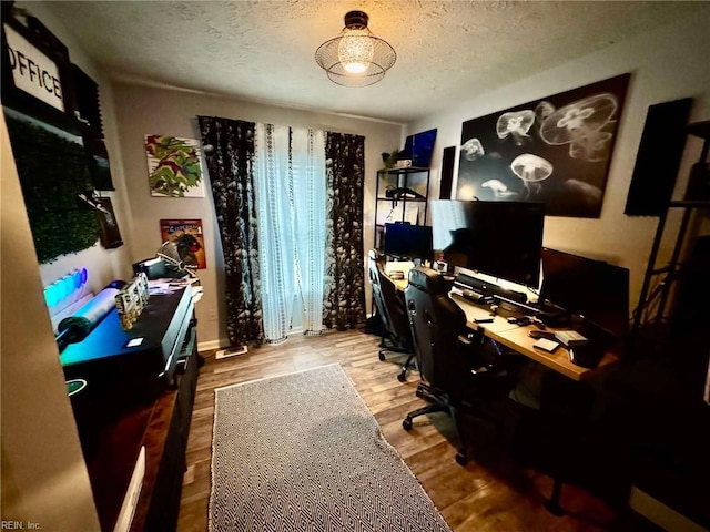 home office featuring wood finished floors and a textured ceiling