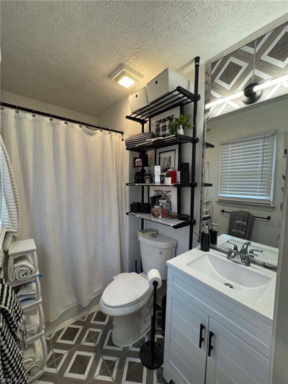 bathroom with tile patterned floors, a textured ceiling, toilet, and vanity