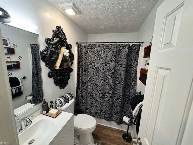 bathroom featuring vanity, toilet, wood finished floors, and a textured ceiling