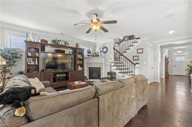 living room with dark wood-style floors, stairway, a fireplace, and ornamental molding