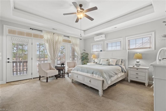 carpeted bedroom with a tray ceiling, ornamental molding, access to exterior, and a wall mounted AC