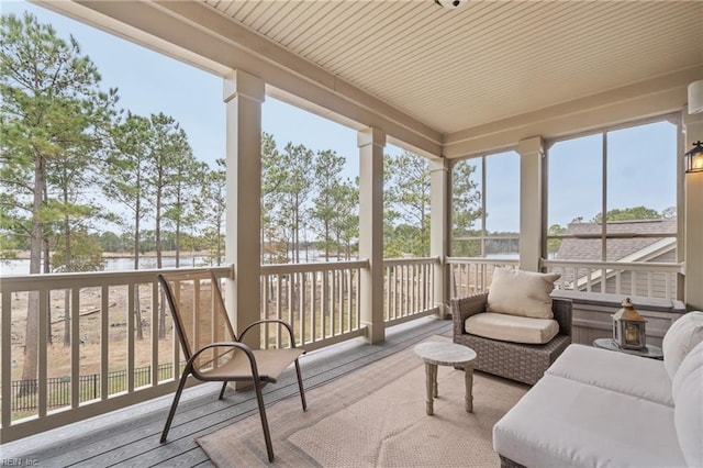 sunroom featuring a water view