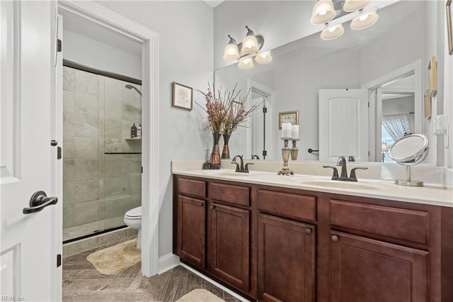 full bathroom featuring a sink, double vanity, a shower stall, and an inviting chandelier