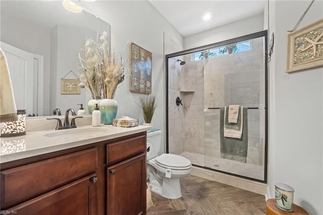 bathroom with toilet, a stall shower, and vanity