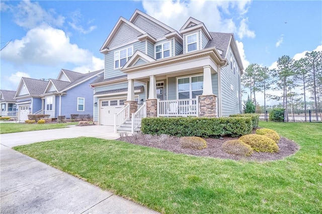 craftsman-style home with driveway, a porch, fence, a front yard, and a garage