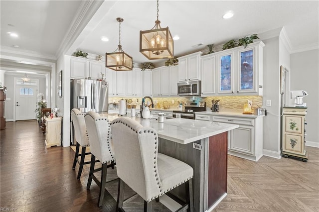 kitchen featuring baseboards, ornamental molding, stainless steel appliances, a kitchen bar, and tasteful backsplash