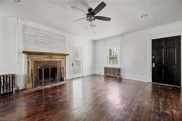 unfurnished living room with crown molding, a fireplace, radiator heating unit, and wood-type flooring