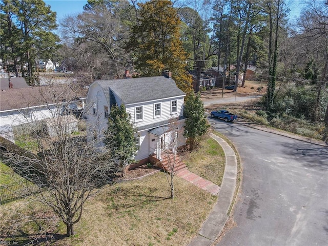 view of front facade featuring a chimney and a front lawn