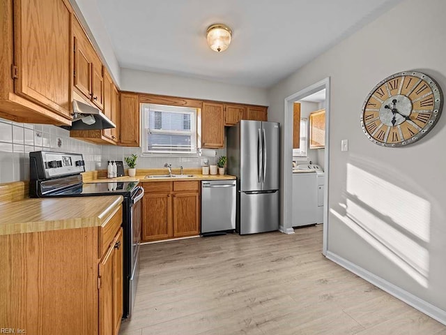 kitchen with a sink, plenty of natural light, under cabinet range hood, and stainless steel appliances