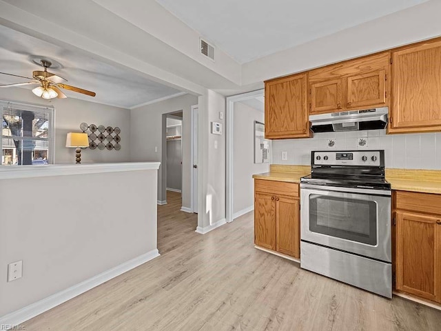 kitchen featuring visible vents, backsplash, under cabinet range hood, light countertops, and stainless steel range with electric stovetop