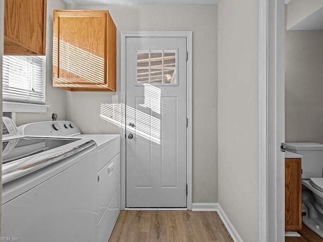 clothes washing area featuring laundry area, independent washer and dryer, baseboards, and light wood-style floors