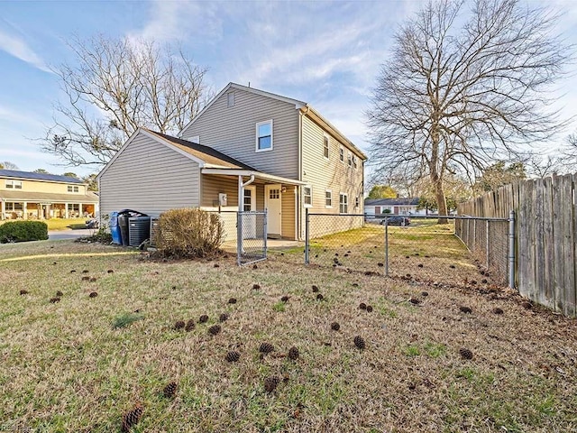 back of property with a yard, central air condition unit, and fence private yard