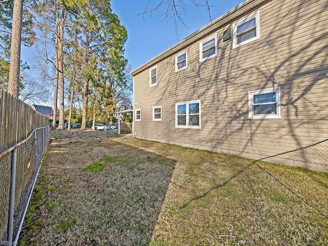 back of property with a lawn and a fenced backyard