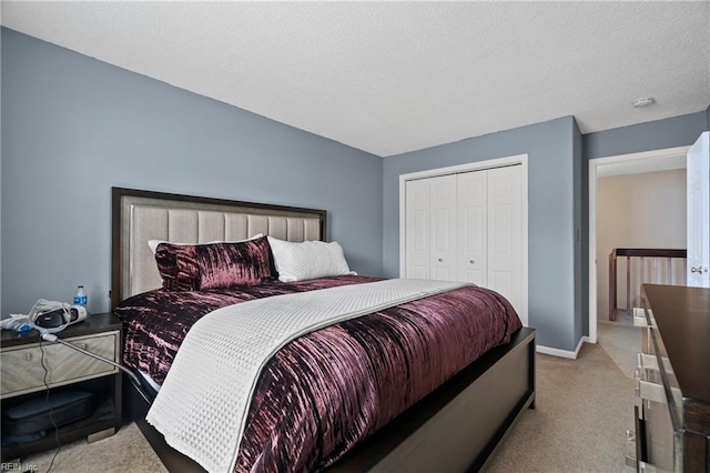 carpeted bedroom with a closet, a textured ceiling, and baseboards