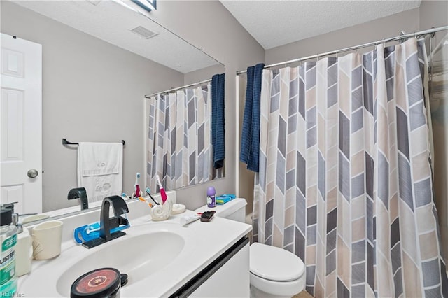 bathroom featuring visible vents, curtained shower, toilet, vanity, and a textured ceiling