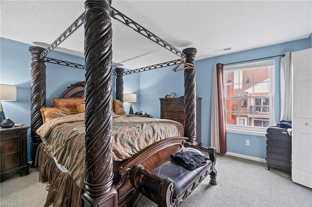 bedroom with carpet flooring, baseboards, visible vents, and a textured ceiling