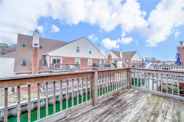 wooden terrace featuring a residential view and a water view