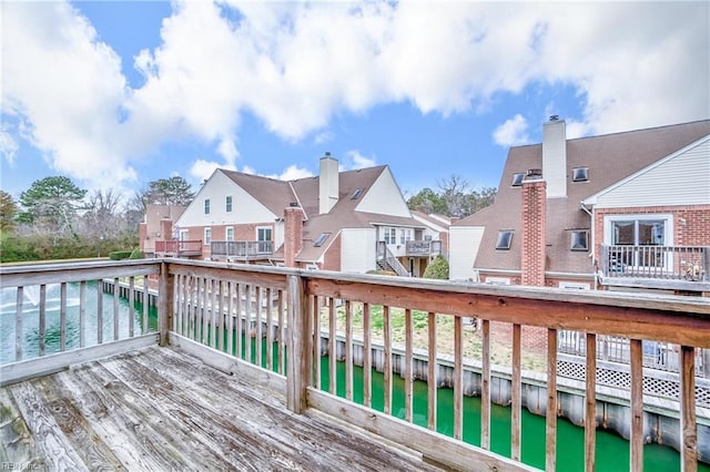 wooden terrace with a residential view and a water view