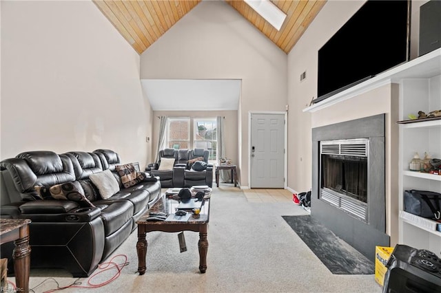 carpeted living room featuring a fireplace with flush hearth, high vaulted ceiling, wood ceiling, and a skylight