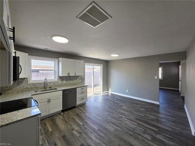 kitchen featuring dishwashing machine, visible vents, a sink, black microwave, and white cabinetry