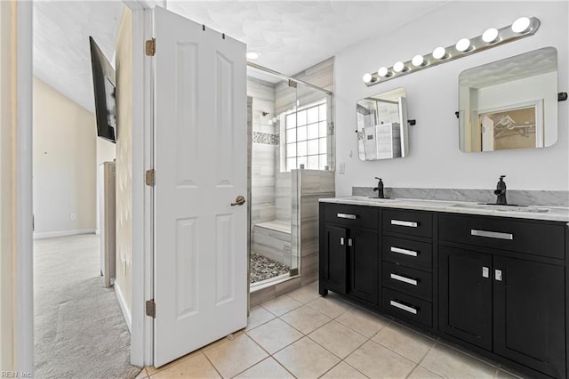 bathroom with a shower stall, double vanity, and a sink