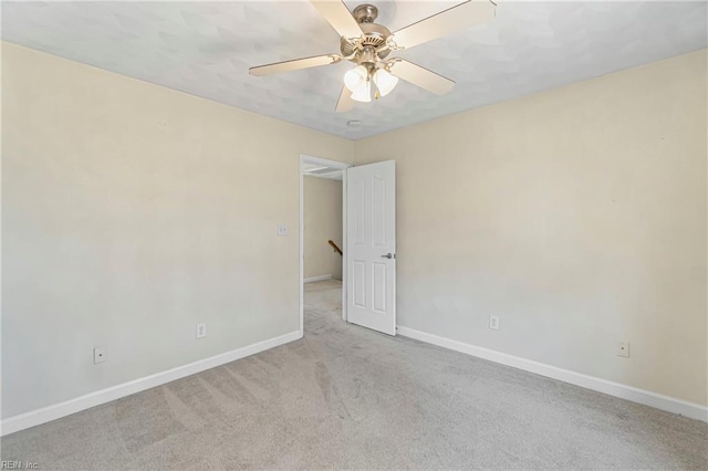 unfurnished room featuring ceiling fan, baseboards, and light carpet