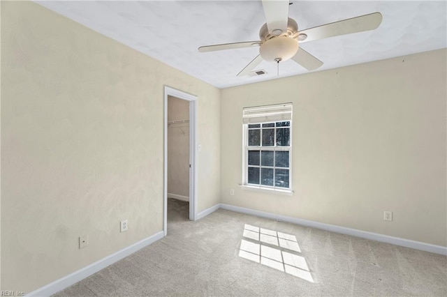 unfurnished bedroom with carpet, visible vents, baseboards, a closet, and a walk in closet