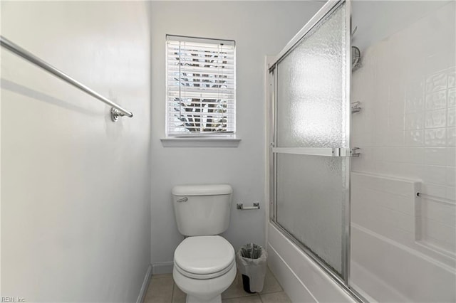 full bathroom with combined bath / shower with glass door, baseboards, toilet, and tile patterned flooring