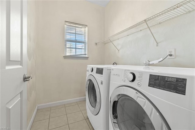 laundry room with washer and dryer, baseboards, laundry area, and light tile patterned floors