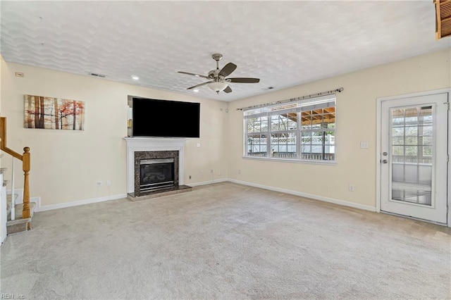 unfurnished living room featuring visible vents, plenty of natural light, carpet, and a fireplace