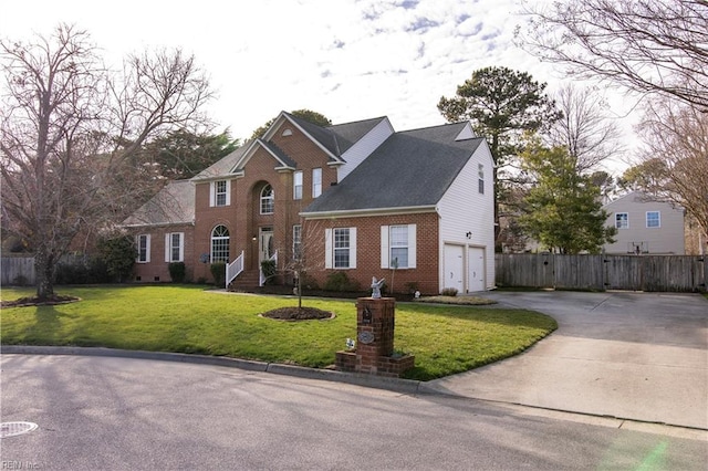 view of front of property with brick siding, fence, concrete driveway, a front yard, and an attached garage