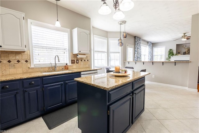 kitchen with plenty of natural light, a sink, decorative backsplash, white cabinetry, and blue cabinets