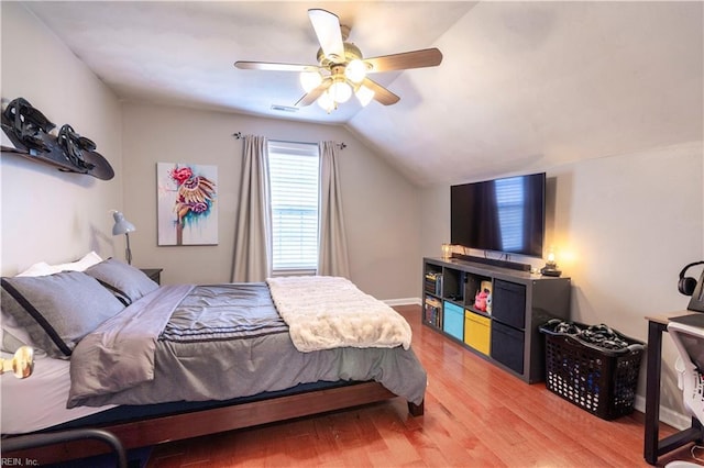 bedroom featuring visible vents, a ceiling fan, baseboards, light wood finished floors, and lofted ceiling