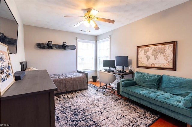 bedroom featuring visible vents, ceiling fan, baseboards, and wood finished floors