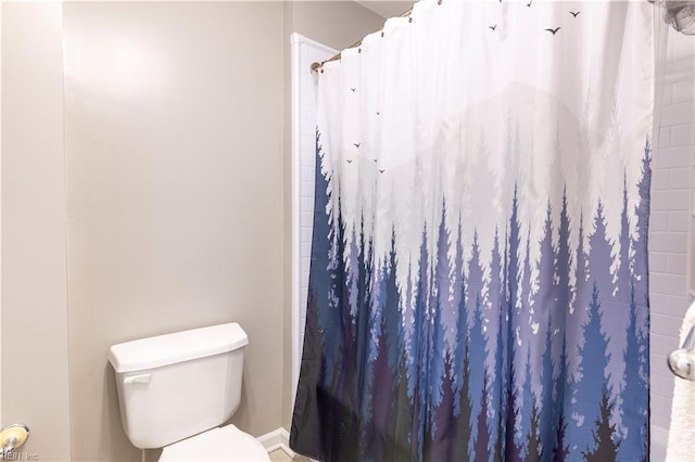 bathroom featuring curtained shower and toilet