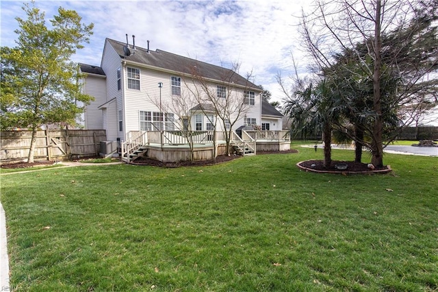 rear view of house featuring central AC unit, a lawn, a wooden deck, and fence