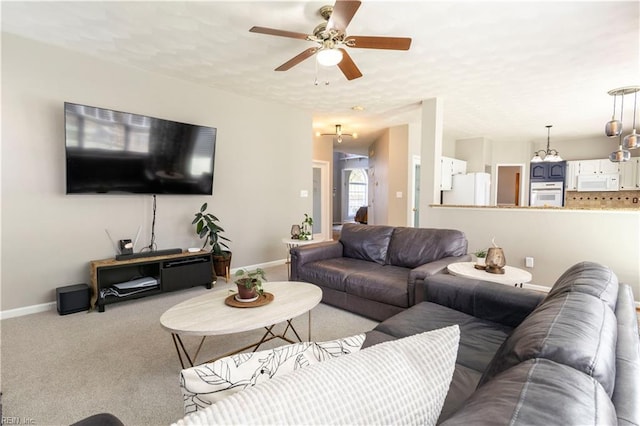 living area with baseboards, a ceiling fan, and carpet flooring