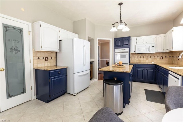 kitchen with a sink, blue cabinets, white appliances, and white cabinetry