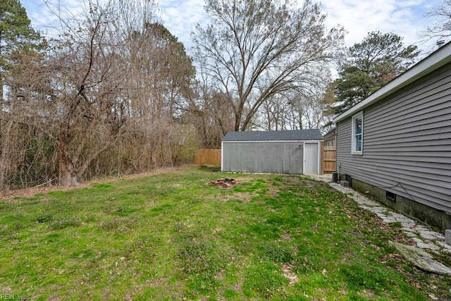 view of yard with an outdoor structure, a shed, and fence