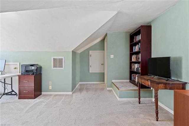 office area with visible vents, baseboards, light colored carpet, and vaulted ceiling