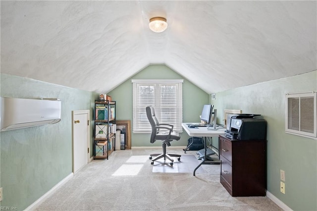 carpeted home office featuring visible vents, a wall unit AC, baseboards, and vaulted ceiling