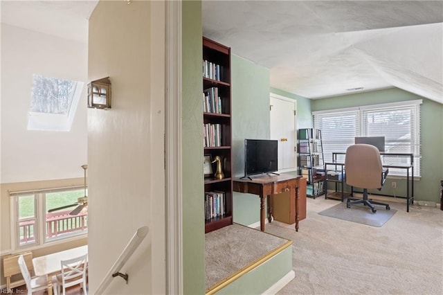 office space with plenty of natural light, lofted ceiling, ceiling fan, and carpet flooring