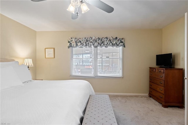 bedroom with a ceiling fan, light colored carpet, and baseboards