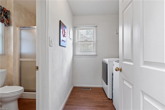 laundry room featuring visible vents, baseboards, laundry area, wood finished floors, and independent washer and dryer