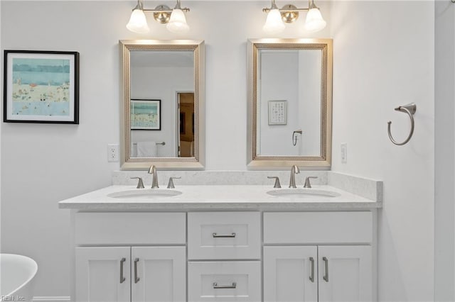 bathroom with double vanity, a soaking tub, and a sink