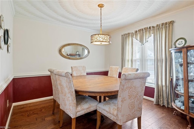 dining room featuring crown molding, baseboards, and wood-type flooring