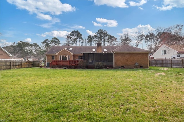 rear view of house featuring a yard, a fenced backyard, a sunroom, a deck, and brick siding