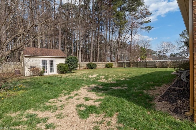 view of yard featuring an outbuilding, french doors, and a fenced backyard