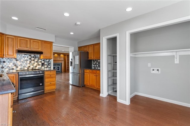 kitchen with tasteful backsplash, visible vents, under cabinet range hood, dark wood finished floors, and appliances with stainless steel finishes